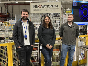 UCalgary authors on the Nature publication, Adam Powell, Pooja Woosaree and Adrew Evans in front of the ALPHA experiment at CERN. 