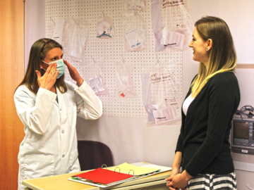 A healthcare provider tries on a mask with a W21C researcher.