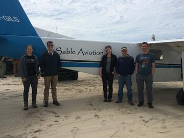 A group of people stand in front of an airplane