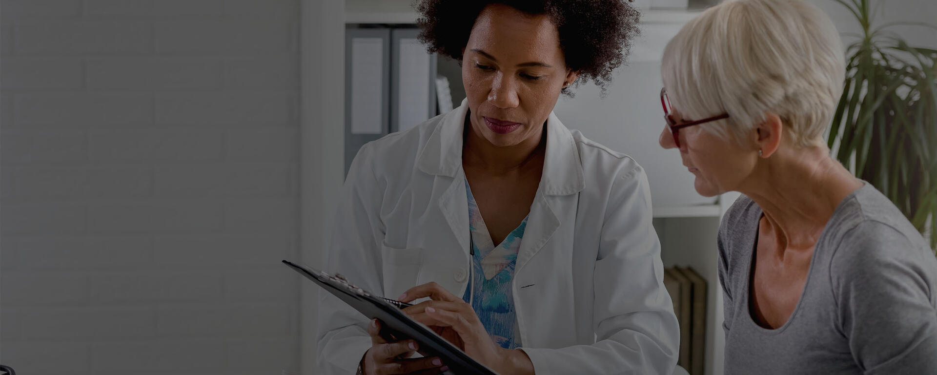 A doctor goes over test results with her senior woman patient.