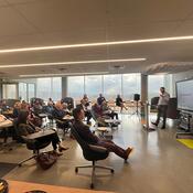 A group of people sit and listen to Dr. Matthew Hill PhD presenting. 
