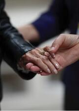 Two Alzheimer's patients holding hands.