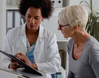 A doctor goes over test results with her senior woman patient.